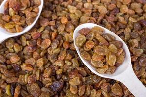 Raisins in a wooden spoon, close-up, food background photo