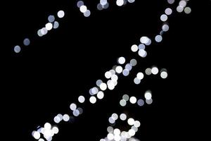 Abstract bokeh of white city lights on black background. defocused and blurred many round light photo