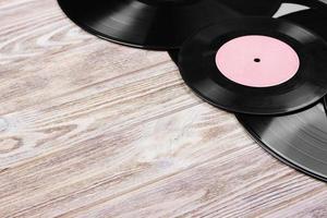 Top view of retro vinyl records over wooden background. Copy space for text photo