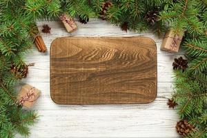 vista superior. placa rectangular de madera vacía sobre fondo de Navidad de madera. concepto de plato de cena navideña con decoración de año nuevo foto