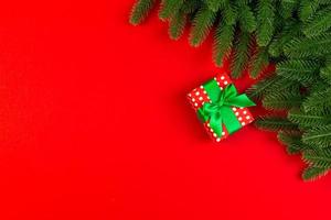 Top view of colorful holiday background made of fir tree and gift box. Happy New Year concept with copy space photo