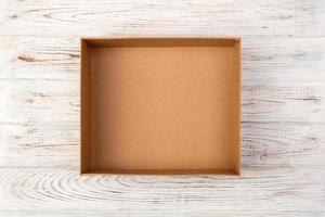 Empty Cardboard box on a white wooden background top view photo