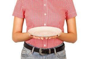 una chica vestida con una camisa roja sostiene un plato blanco vacío para tu plato. plantilla de vista en perspectiva para su diseño. aislado sobre fondo blanco foto