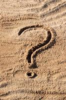 signos de interrogación escritos en la arena de la playa de cerca, con espacio de copia foto