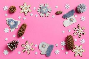 Top view of holiday toys and decorations on pink Christmas background. New Year time concept with copy space photo