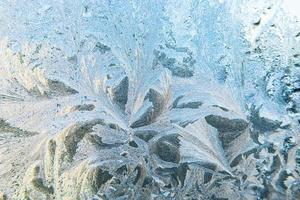 Frozen winter window with shiny ice frost pattern texture. Christmas wonder symbol, abstract background. Extreme north low temperature, natural Ice snow on frosty glass, cool winter weather outdoor. photo