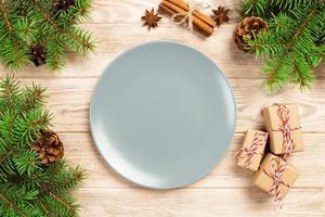 Empty gray matte plate on wooden background with christmas decoration, Round dish. New Year concept photo