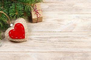 Christmas background with fir branches, knitted heart and gift boxes on white wooden table. Christmas background. Flat lay. top view with copy space photo