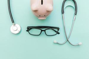 Equipo médico de medicina estetoscopio o fonendoscopio hucha gafas aislado sobre fondo azul pastel de moda foto