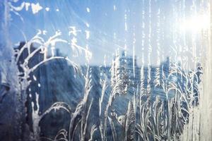 Frozen winter window with shiny ice frost pattern texture photo