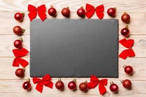 Top view of holiday dinner on wooden background. Plate, baubles and bows. Christmas Eve concept photo