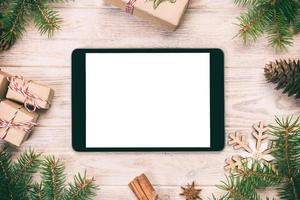 Digital tablet mock up with rustic Christmas wood vintage, toned background decorations for app presentation. top view with copy space photo