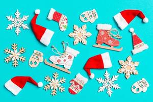 Top view of Christmas decorations and Santa hats on blue background. Happy holiday concept photo