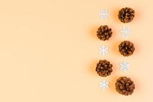 Top view of New Year ornament made of white snowflakes and pine cones on colorful background. Winter holiday concept with empty space for your design photo