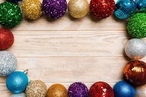 Top view of frame made of decorative balls on wooden background. Christmas toys concept with empty space for your design photo