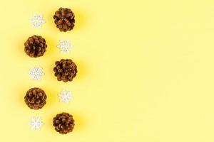 Top view of holiday composition made of pine cones and white snowflakes on colorful background. Winter time and Christmas concept with copy space photo