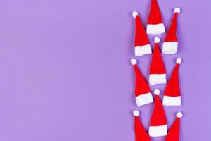 Top view od stylish red Santa hats on colorful background. Merry Christmas concept with copy space photo