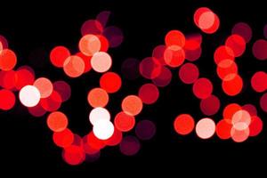 Unfocused abstract red bokeh on black background. defocused and blurred many round light photo