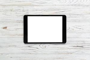 black digital tablet on rustic wooden table background. mock up top view photo