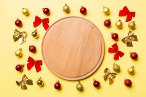 Top view of holiday dinner on colorful background. Plate, baubles and bows. Christmas Eve concept photo