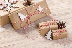 Christmas gift box with decoration on wooden background photo