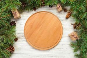 top view. Empty wood round plate on wooden christmas background. holiday dinner dish concept with new year decor photo