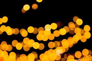 Unfocused abstract yellow bokeh on black background. defocused and blurred many round light photo