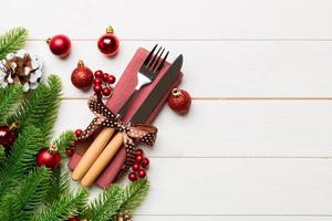 Top view of festive cutlery on new year wooden background. Christmas decorations with empty space for your design. Holiday dinner concept photo