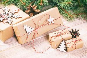 Christmas gift box with decoration on wooden background. Toned photo