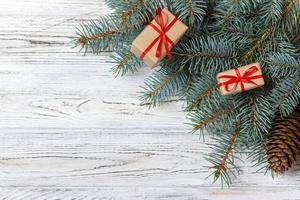 Christmas gift boxes and fir tree branch on wooden table. Top view with copy space photo