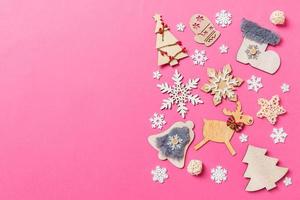 Top view of holiday decorations and toys on pink background. Christmas ornament concept with empty space for your design photo