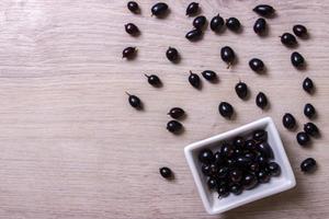 black currant in glassware on white wooden table top view photo