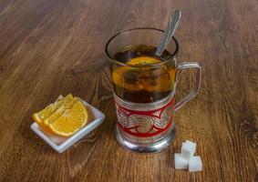 sweet cup of fruit tea with lemon and sugar. photo