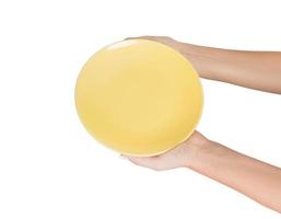 Blank empty round yellow plate in female hand. perspective view, isolated on white background photo