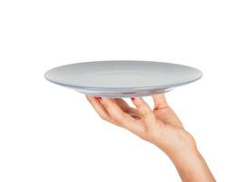 Blank empty round gray matte plate in female hand. perspective view, isolated on white background photo