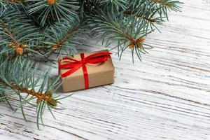 Christmas gift boxes and fir tree branch on wooden table. Top view with copy space photo
