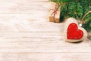 Christmas background with fir branches, knitted heart and gift boxes on white wooden table. Christmas background. Flat lay. top view with copy space. Toned photo