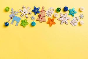 vista superior de fondo amarillo con juguetes y decoraciones de año nuevo. concepto de tiempo de navidad con espacio de copia foto