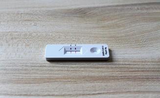 Positive test result by use antigen rapid test for COVID-19 on wooden background with copy space. Healthy check, Corona virus infection, Pandemic infectious and Medical. Initial symptom check. photo