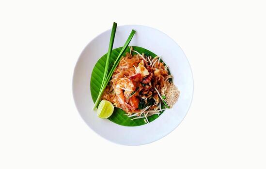 Top view of stir fried with rice noodle, river prawns or shrimp, bean sprout, sliced chives and lime on banana leaf isolated on white background with clipping path and make selection. Pad Thai menu. photo