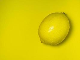 un limón entero sobre un fondo amarillo. cítricos en la mesa. fondo brillante alimentos fortificados saludables para un producto vegetariano.sour foto