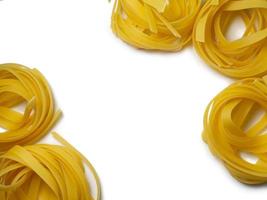 Pasta nests on a white background. Culinary background. Curled pasta on the table. Uncooked product.  Background from noodles. photo