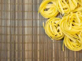 Pasta nests on a wicker background. Type of noodle. Culinary background. Cooking. photo