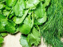 Mix of greens from the garden. Parsley, cilantro, dill on the kitchen table. Cooking. Useful food. Spices for the dish. Salad preparation. photo