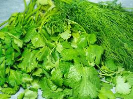 Mix of greens from the garden. Parsley, cilantro, dill on the kitchen table.  Useful food. Spices for the dish. Salad preparation. Green coriander. photo