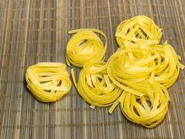 Pasta nests on a wicker background. Type of noodle. Culinary background. Cooking. photo