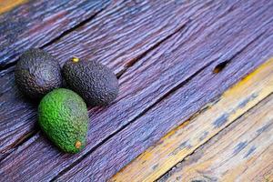 Fresh green avocado on a wooden table is a very useful and vitamin fruit. photo