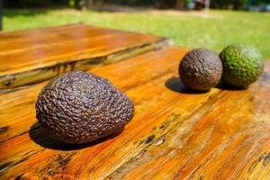 el aguacate verde fresco sobre una mesa de madera es una fruta muy útil y vitamínica. foto