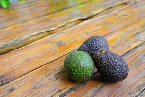 Fresh green avocado on a wooden table is a very useful and vitamin fruit. photo