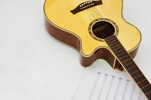 guitarra acústica con notas musicales sobre fondo blanco. concepto de amor y música. foto